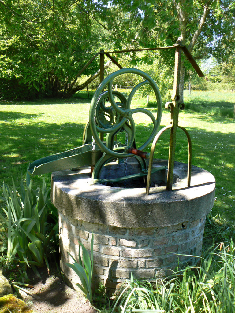 ancienne pompe à eau manuelle sur un puits dans le jardin